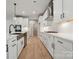 Stylish kitchen featuring white cabinets, stainless steel appliances, a farmhouse sink, and modern fixtures at 404 Balboa St, Matthews, NC 28104