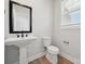 Stylish powder room with a pedestal sink, modern faucet, and a toilet with a window for natural light at 404 Balboa St, Matthews, NC 28104