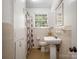 Cozy bathroom with tile walls, pedestal sink, and a window letting in natural light at 412 Keels Ave, Rock Hill, SC 29730