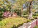 Mature trees and green foliage in a yard with sheds and a low retaining wall at 412 Keels Ave, Rock Hill, SC 29730