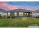 A tranquil backyard view at sunset with grass lawn and dark gray siding with a screened-in porch at 4171 Canopy Creek Dr, Denver, NC 28037