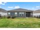 A rear view of the home with a grassy lawn, showing the screened porch, siding, and dark gray trim at 4171 Canopy Creek Dr, Denver, NC 28037