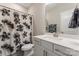 Bathroom features a tub shower, floral curtain, a single sink, white cabinets and granite counters at 4171 Canopy Creek Dr, Denver, NC 28037