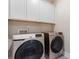 A clean laundry room featuring overhead cabinets, with new, stylish Samsung washer and dryer at 4171 Canopy Creek Dr, Denver, NC 28037
