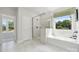 This bright and airy bathroom features a tiled shower and tub, plus a view of the beautiful back yard at 424 Balboa St, Matthews, NC 28104