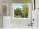 A bright bathtub area features elegant marble and a view to the private wooded back yard at 424 Balboa St, Matthews, NC 28104