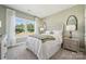 Serene bedroom with a large window, soft green walls, and a carved headboard over white bedding at 424 Balboa St, Matthews, NC 28104