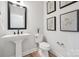 Modern powder room featuring a pedestal sink, toilet, and decorative wall art for an elegant touch at 424 Balboa St, Matthews, NC 28104