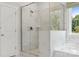 A marble walk-in shower provides an airy and luxurious experience with natural light from the back yard at 424 Balboa St, Matthews, NC 28104