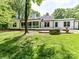 Back of the home showcasing a spacious deck, a stone fire pit, and beautifully landscaped backyard at 4301 Middle Stream Rd, Charlotte, NC 28213
