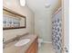 Clean bathroom with a single sink vanity, shower, and neutral color palette at 4301 Middle Stream Rd, Charlotte, NC 28213