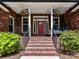 Inviting front porch with brick steps, a porch swing, and beautiful landscaping at 4301 Middle Stream Rd, Charlotte, NC 28213