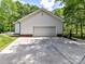 Side angle view of a two-car garage with a concrete driveway and brick foundation at 4301 Middle Stream Rd, Charlotte, NC 28213