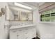 Bright bathroom featuring a double vanity with marble countertop and decorative mirrors at 4360 Woodglen Ln, Charlotte, NC 28226