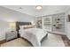 Bright bedroom features built-in bookshelves, a queen bed, and a large window at 4360 Woodglen Ln, Charlotte, NC 28226