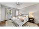 Bright bedroom featuring a ceiling fan, a plush rug, and large windows at 4360 Woodglen Ln, Charlotte, NC 28226