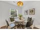 Bright breakfast nook with banquette seating, round table, and unique light fixture at 4360 Woodglen Ln, Charlotte, NC 28226
