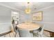 Cozy dining room with a round wood table, gray chairs, and stylish light fixture at 4360 Woodglen Ln, Charlotte, NC 28226