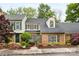 Charming brick townhome featuring a well-maintained front yard with colorful flowers and mature trees at 4360 Woodglen Ln, Charlotte, NC 28226