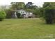 A home set in a green lawn, surrounded by trees, creating a sense of privacy and a natural backdrop at 4671 Lucas Ct, Harrisburg, NC 28075