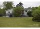 Cozy home with a simple facade, surrounded by greenery and featuring a modest front porch and yard at 4671 Lucas Ct, Harrisburg, NC 28075