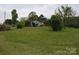 Home surrounded by a large grassy area and mature trees at 4671 Lucas Ct, Harrisburg, NC 28075