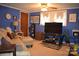 Comfortable living room with blue walls, neutral carpet, and a large TV, creating a relaxed atmosphere at 4671 Lucas Ct, Harrisburg, NC 28075