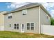 This backyard features a large grassy area, an access door, and white fencing at 5030 Ashley Place Dr, Bessemer City, NC 28016