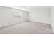 This bedroom features neutral walls, carpeted floors, and a window letting in natural light at 5030 Ashley Place Dr, Bessemer City, NC 28016