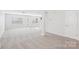 Open living room features neutral carpet, natural light, and a door to the backyard at 5030 Ashley Place Dr, Bessemer City, NC 28016