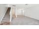 Bright and airy living room with neutral carpet and staircase at 5030 Ashley Place Dr, Bessemer City, NC 28016