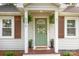 Welcoming front entrance featuring a green door, sidelight windows, and potted plants at 506 Englewood Ne St, Concord, NC 28025