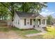 Charming home featuring white siding, a green front door, and a well-maintained lawn at 506 Englewood Ne St, Concord, NC 28025