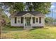 Charming cottage-style home with white siding, brown shutters, and a landscaped front yard at 506 Englewood Ne St, Concord, NC 28025