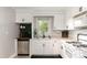 Bright kitchen with white cabinets, modern appliances, and a charming backsplash at 506 Englewood Ne St, Concord, NC 28025