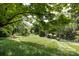 Serene backyard with mature trees, green lawn, and plenty of shade at 5128 Dunes Ct, Charlotte, NC 28226
