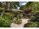 Landscaped garden featuring a stone bench, flowers, and decorative gravel, offering a peaceful outdoor retreat at 5128 Dunes Ct, Charlotte, NC 28226