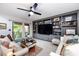 Bright and airy living room with a ceiling fan, built-in shelving, and access to the deck at 5128 Dunes Ct, Charlotte, NC 28226