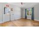 Bedroom with hardwood floors, neutral walls, window with curtains, and an exit door at 536 Hartness Rd, Statesville, NC 28677