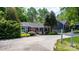 Charming brick ranch home with mature landscaping, a red door, and a ramp for accessibility at 536 Hartness Rd, Statesville, NC 28677