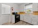 Kitchen featuring an electric oven, sink, white cabinets, and a window at 536 Hartness Rd, Statesville, NC 28677