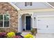 Stylish front entrance with a blue door, stone accents, and manicured flower beds at 536 Rustlewood Way, Rock Hill, SC 29732