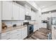 Well-lit kitchen featuring white cabinetry, granite countertops, stainless steel appliances, and wood flooring at 536 Rustlewood Way, Rock Hill, SC 29732