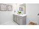 Bright bathroom featuring a double sink vanity, framed mirror, white countertop, and grey cabinets at 6165 Helens Rest Ln, Lincolnton, NC 28092