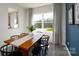 Bright dining area with wood table, black chairs, and natural light from a large window with peaceful backyard views at 6165 Helens Rest Ln, Lincolnton, NC 28092