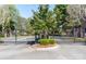 Gated community entrance with lush landscaping and mature trees on a sunny day at 6231 Wakehurst Rd, Charlotte, NC 28226