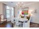 Bright dining room with elegant chandelier, white table, and large windows with nice trim at 6231 Wakehurst Rd, Charlotte, NC 28226