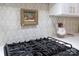 Close-up of a kitchen featuring a gas cooktop, decorative backsplash, and white countertops at 6231 Wakehurst Rd, Charlotte, NC 28226