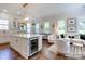 Bright living space featuring a kitchen island with wine cooler, dining area, and comfortable seating at 6231 Wakehurst Rd, Charlotte, NC 28226