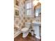 Stylish powder room with unique wallpaper, pedestal sink, and decorative mirror at 6231 Wakehurst Rd, Charlotte, NC 28226